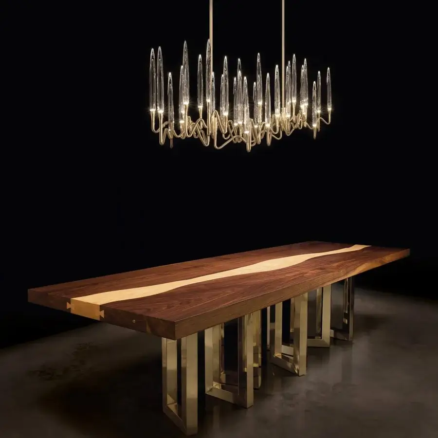 Exceptional Il Pezzo 3 Long Chandelier crafted in hand-forged warm gold tone brass with clear solid crystal diffusers