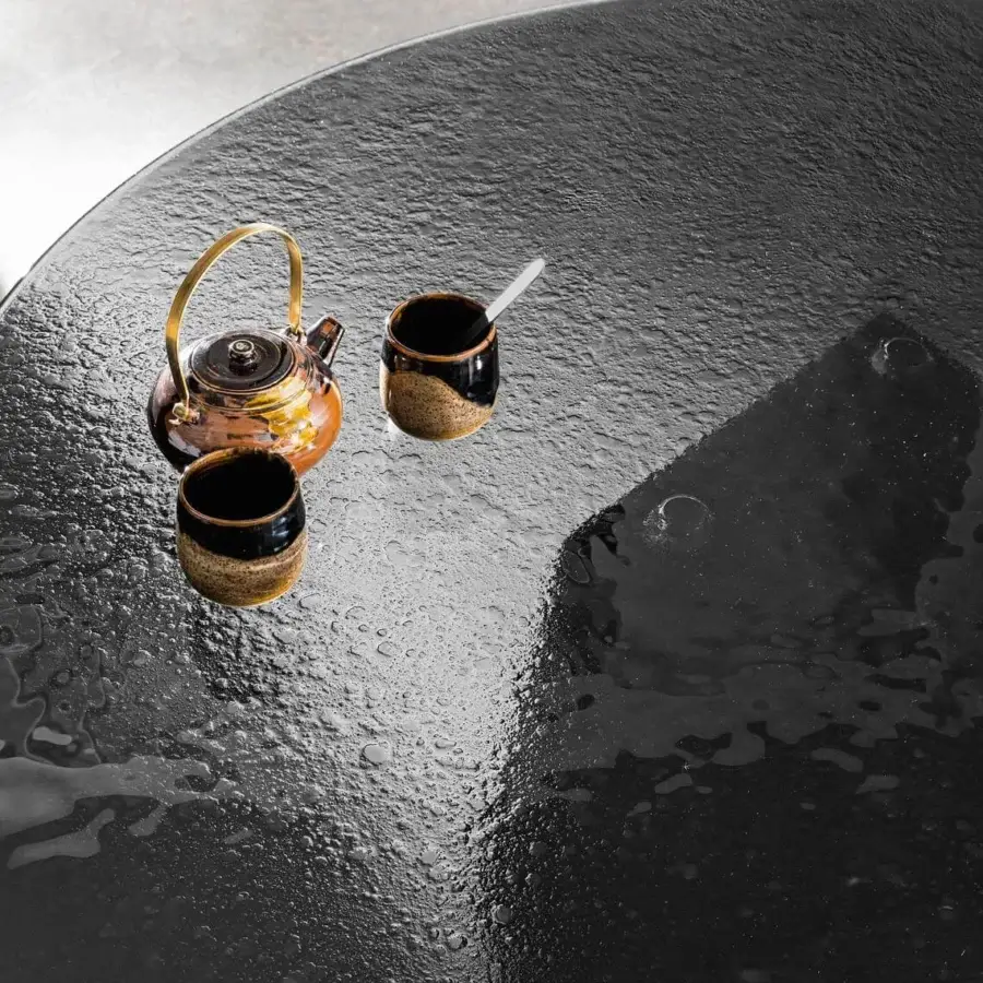 Captivating Sovet Italia Deod round table with a sculptural lacquered metal base and tempered liquid glass top exhibiting a dark textured finish