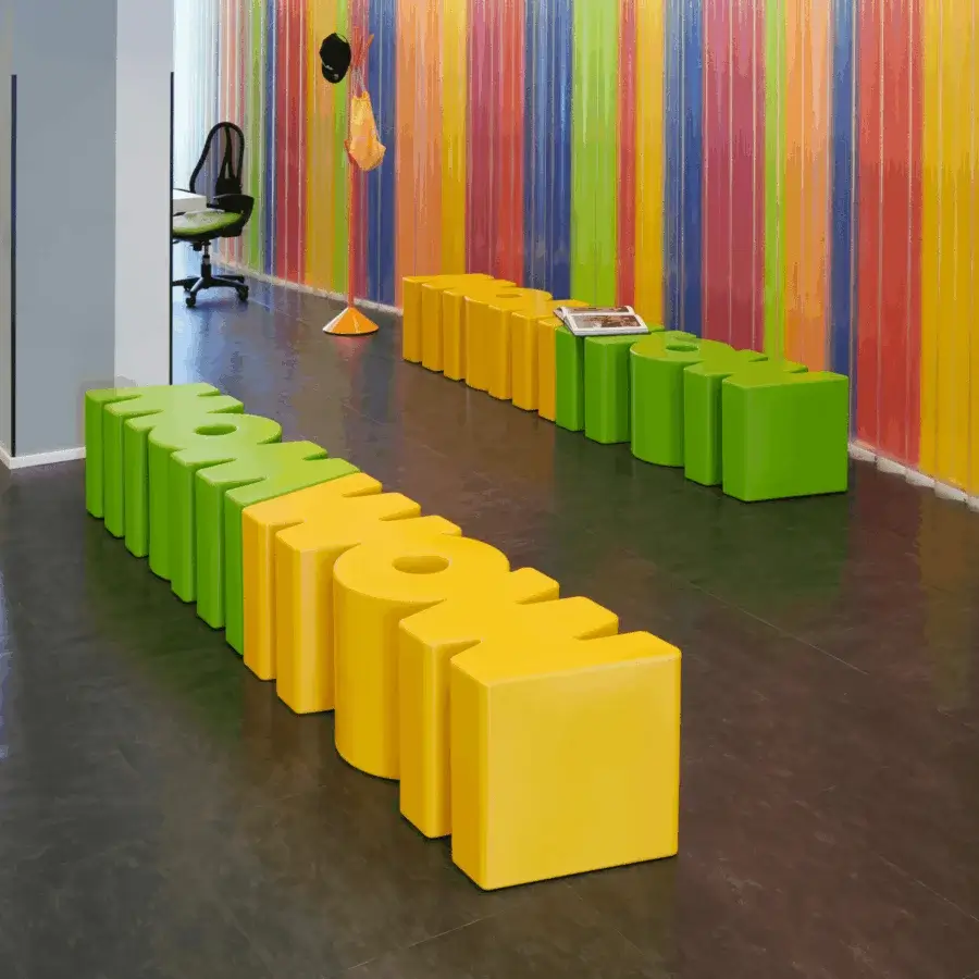 Sophisticated Slide Wow bench in vibrant yellow and green polyethylene with a sculptural clean semi-gloss finish design