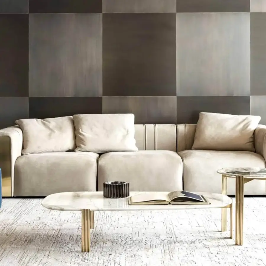 Exclusive Rugiano Luz sofa upholstered in light beige textile with uniquely curved armrests and refined brushed brass detailing
