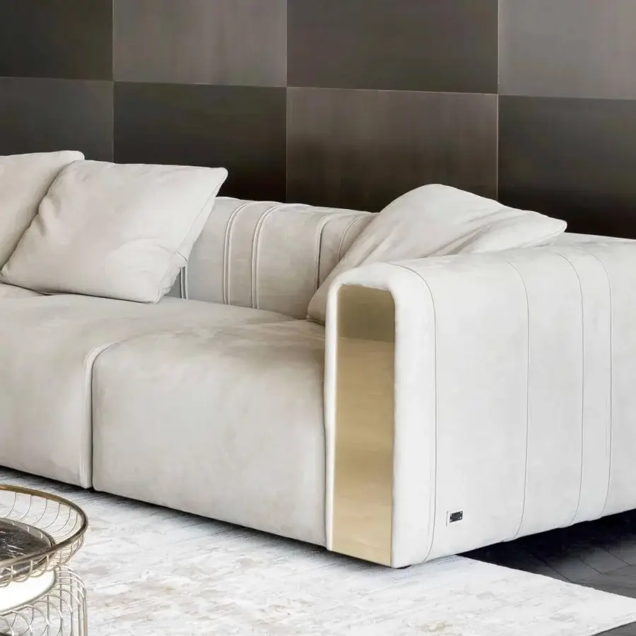 Superior Rugiano Luz sofa upholstered in light beige textile with brushed brass detailing and vertical stitched backrest