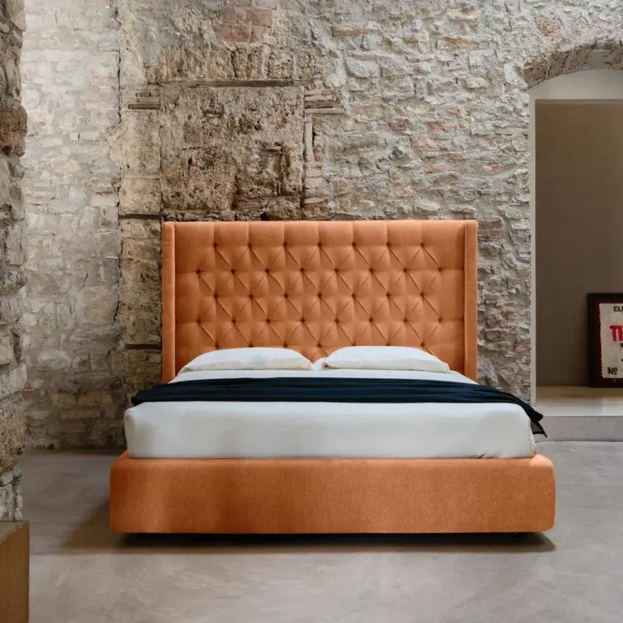 Exquisite Noctis Star bed in vibrant orange textile featuring hand tufted capitonne detailing and winged sides