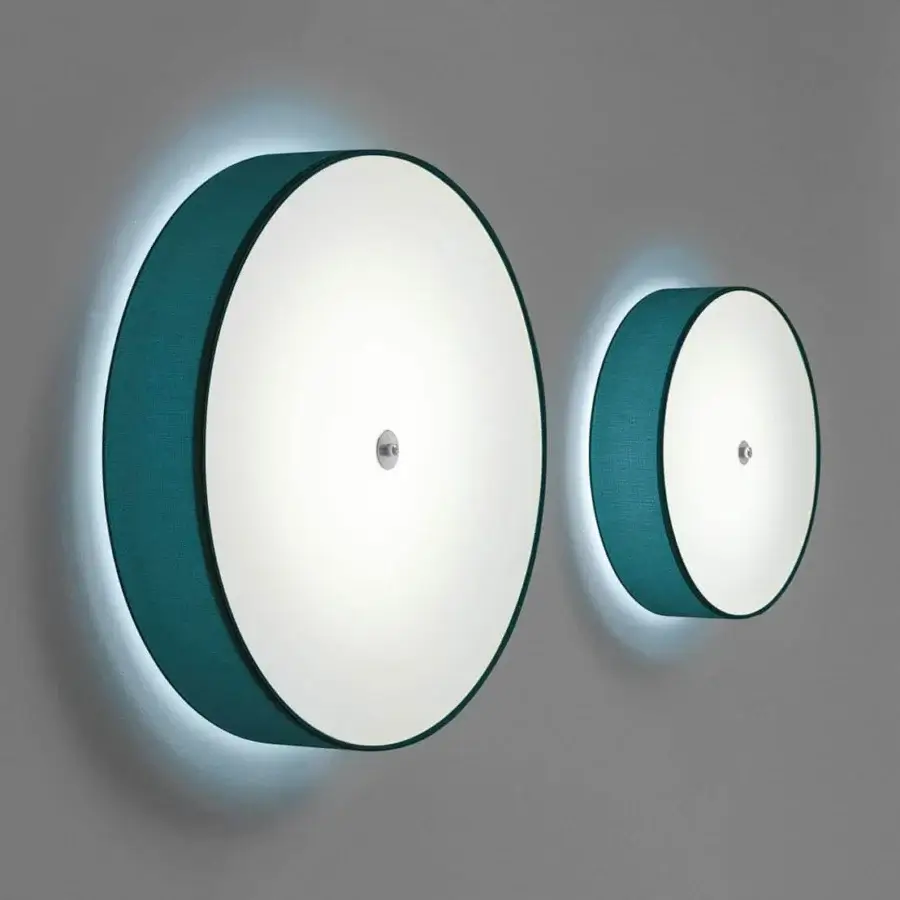 Elegant Modo Luce Discovolante wall lamp with a circular form and teal fabric encircling a bright light-emitting surface