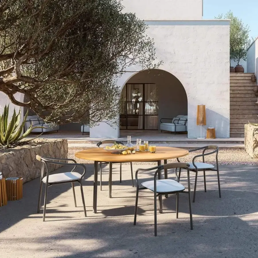 Sophisticated Unopiù Versilia table featuring circular solid teak top, natural matte finish, and dark aluminium base