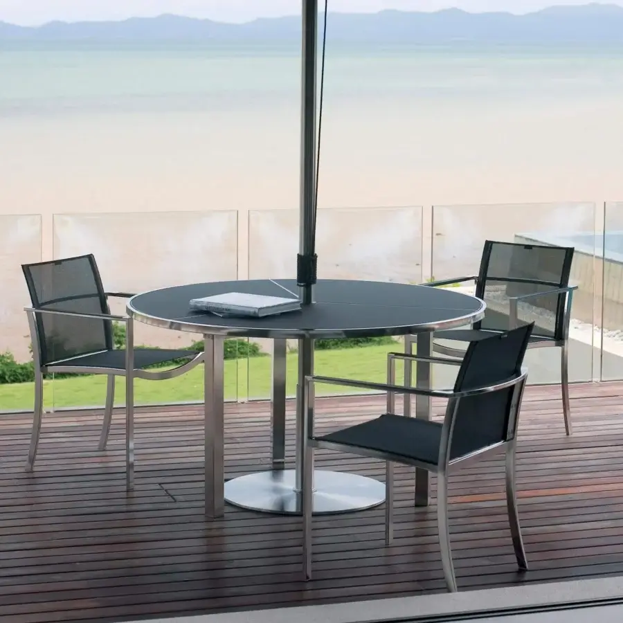 Elegant Royal Botania O-Zon chair with brushed stainless steel frame and dark Batyline seat offering a sleek, minimalist aesthetic