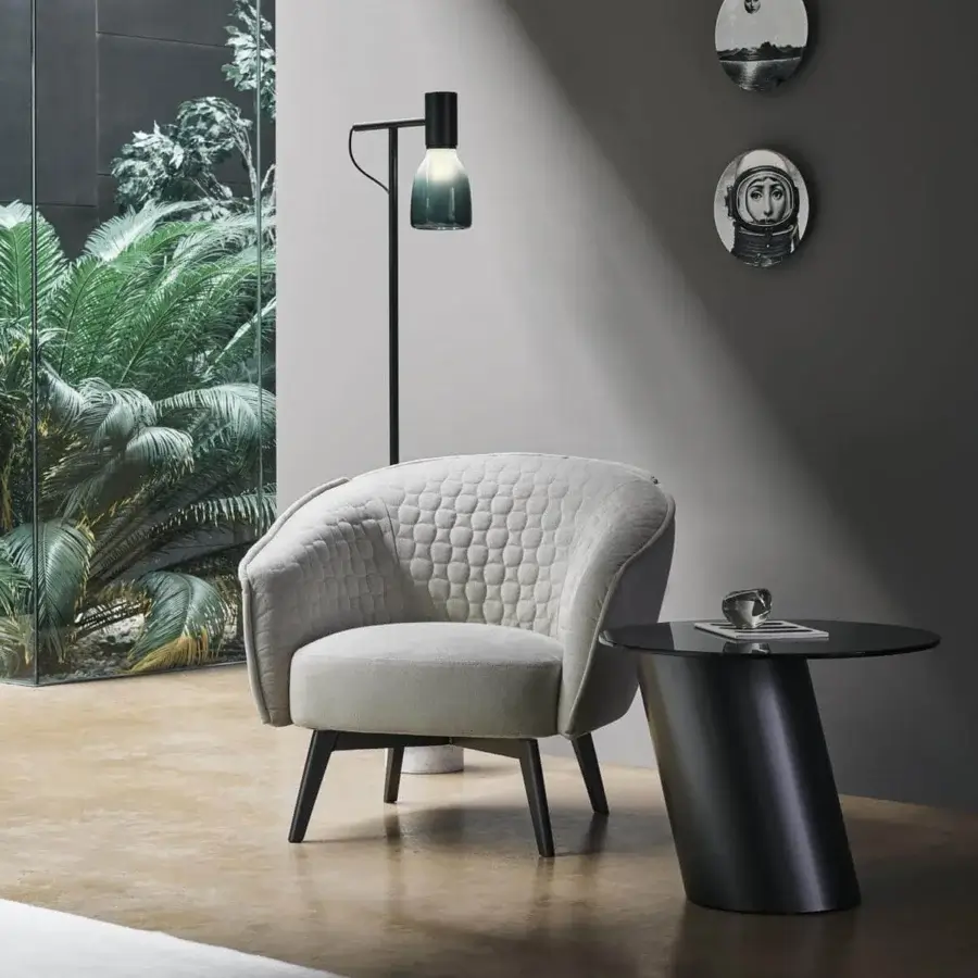 Refined Bonaldo Bruno lounge chair with generous padding and curved shapes in light gray quilted fabric with dark-toned metal legs