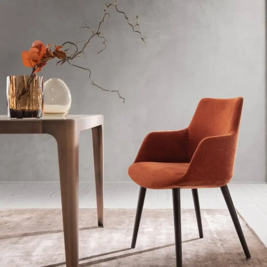 Elegant Presotto Divina armchair with soft enveloping shape upholstered in textured burnt orange textile and black lacquer ash legs