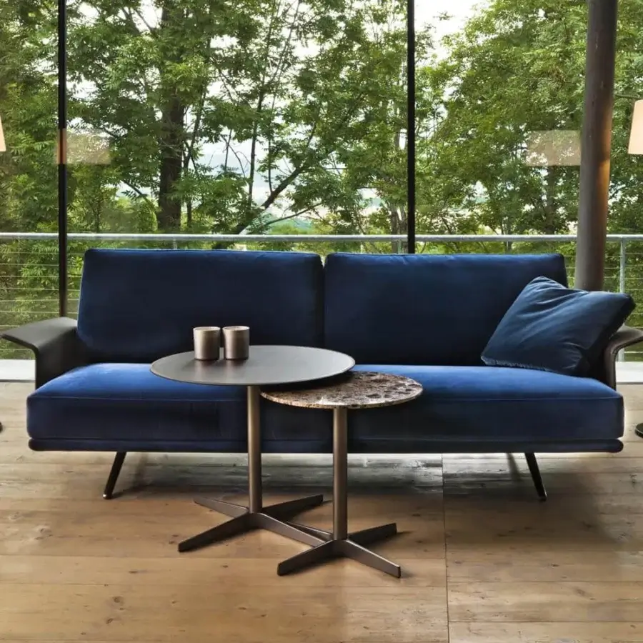 Innovative Verzelloni Nilson sofa with a sleek silhouette upholstered in plush blue textile and refined dark-toned leather armrests