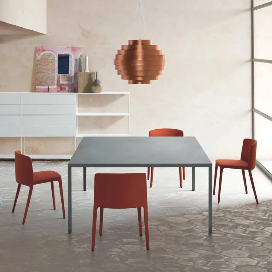 Distinguished MDF Italia Achille chair with muted orange upholstery and metal tubing built with polyurethane rubbers showcasing a matte finish