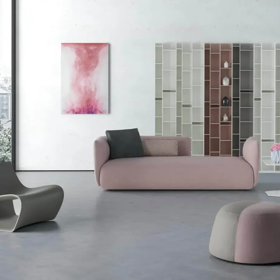 Elegant MDF Italia Cosy sofa with curved lines upholstered in muted rose textile and standard decorative cushions