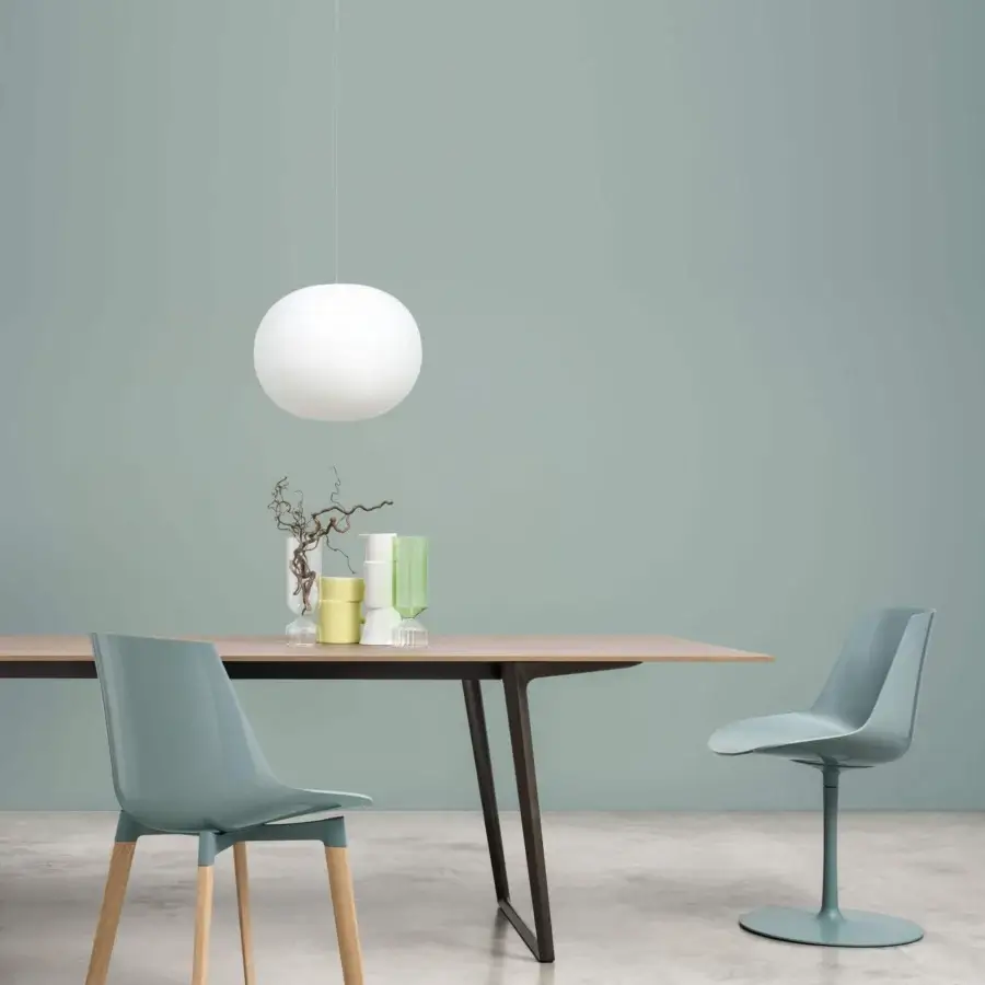 Distinguished MDF Italia Flow chair with a curved shell in muted blue-green synthetic material and wooden legs or pedestal base
