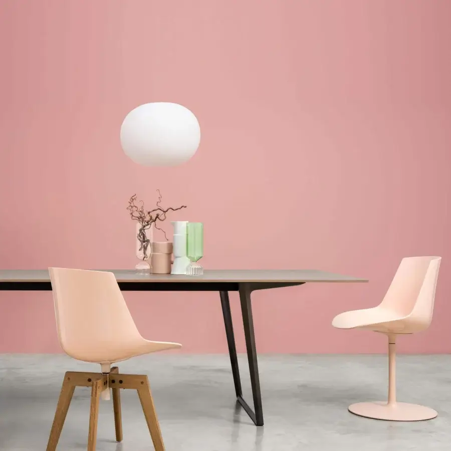 Distinguished MDF Italia Flow chair with a curved silhouette and glossy peach shell paired with wooden or central post bases