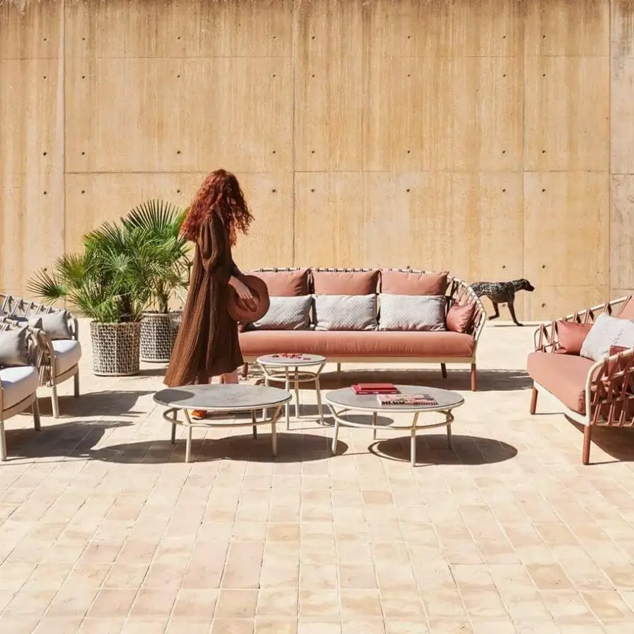 Exceptional Varaschin Emma Cross sofa with handwoven acrylic Band detailing and plush salmon-coral cushions with powder-coated aluminum frame