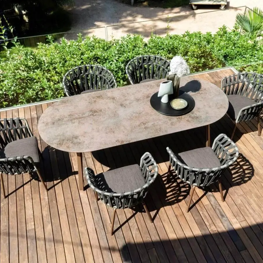 Distinguished Varaschin Emma table built with bush-hammered ceramic in mottled browns, tans and greys with Iroko wood legs and powder-coated aluminum frame