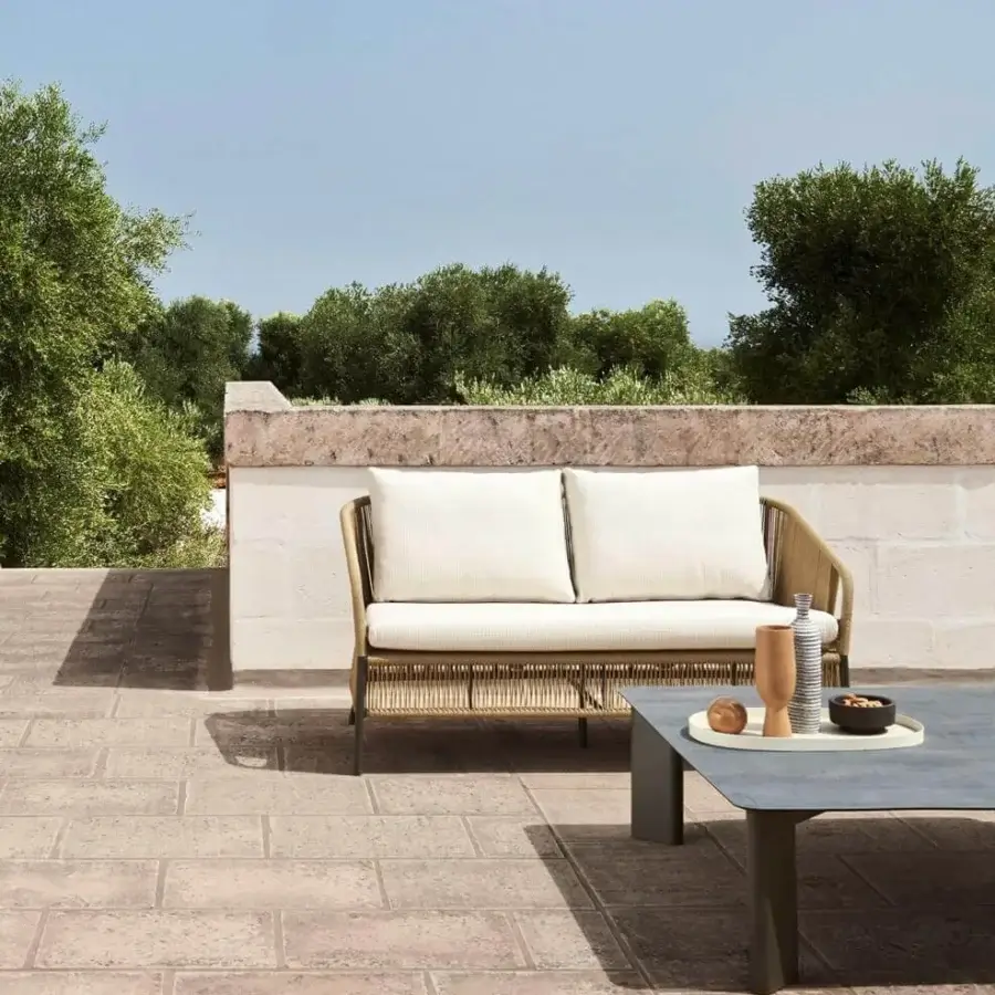 Elegant Varaschin Cricket sofa with hand-woven light rope wrapping and neutral cushions built on dark metal legs