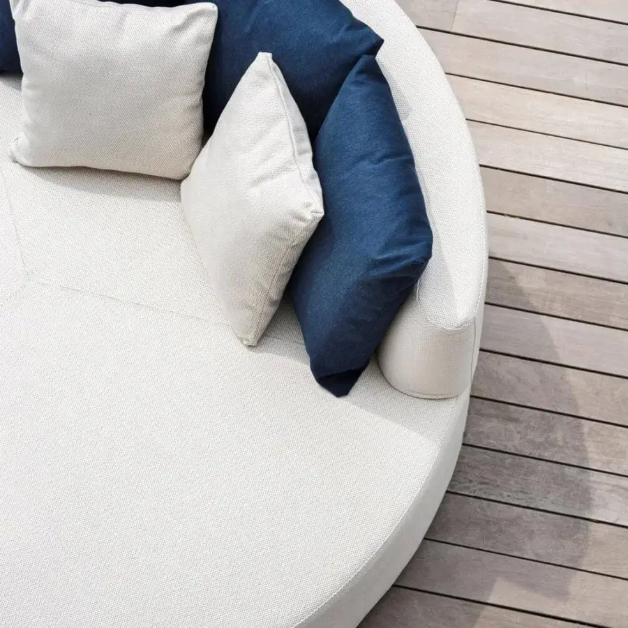 Elegant Varaschin Belt daybed upholstered in off-white woven textile with dark blue cushions and okumè wood structure