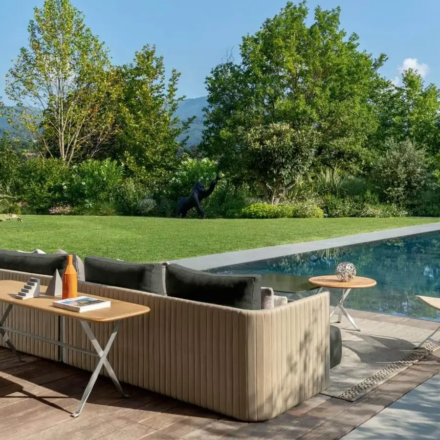 Distinguished Talenti George sofa with neutral beige textile upholstery and dark gray cushions, completed with a stainless steel console in accoya wood or lava stone