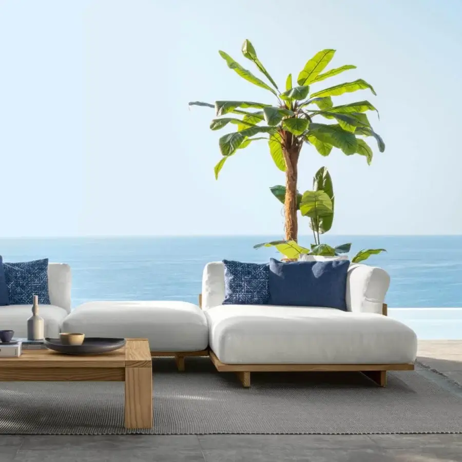 Distinguished Talenti Argo Wood sectional with solid accoya wood frame, white cushions and contrasting blue pillows, exhibiting a smooth natural finish