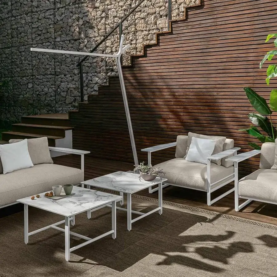 Elegant Talenti Riviera lounge chair with light beige textile cushions and stoneware armrests in a white frame