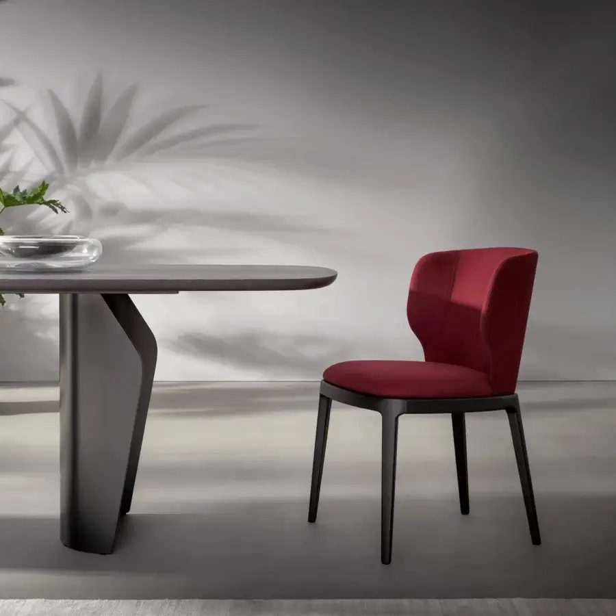Elegant Bonaldo Joy chair with enveloping seat and backrest in deep red textile and dark-toned wood legs