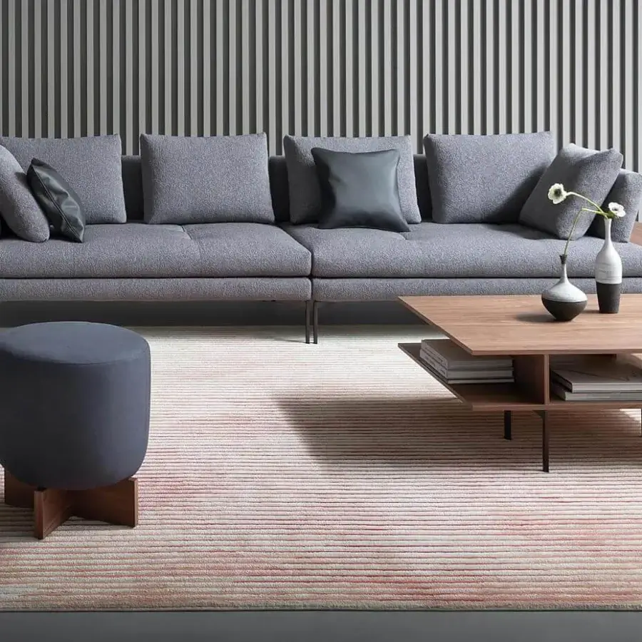 Refined Bonaldo Belt & Cross ottoman with floating padded top and cross-shaped wooden base in dark gray textile upholstery with matte finish