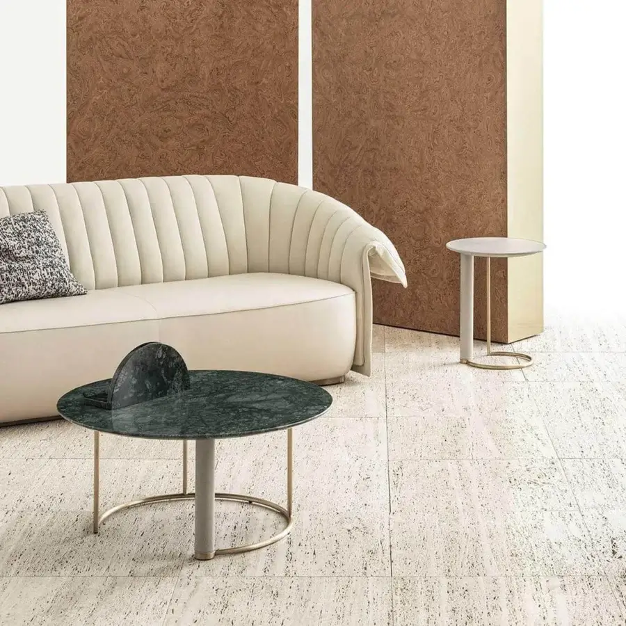 Distinctive Rugiano Manta sofa with smooth light cream textile upholstery and vertically channel-tufted backrest built on a bronze plinth base