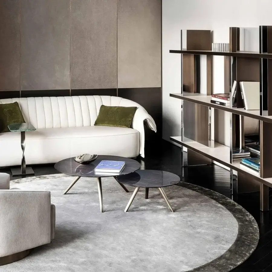 Elegant Rugiano Manta sofa with sinuous form, white textile upholstery and bronze plinth base with dark green pillows