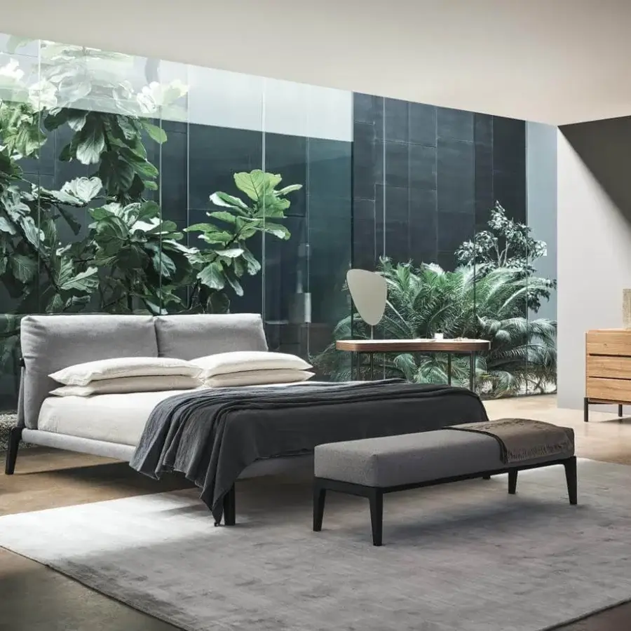 Exclusive Bonaldo Kriss bed with light grey textile headboard and frame built with dark-toned wooden legs