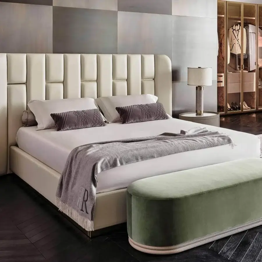 Superior Rugiano Victoria bed with light cream textile upholstery, vertical paneling and brass detailing crafted in Italy