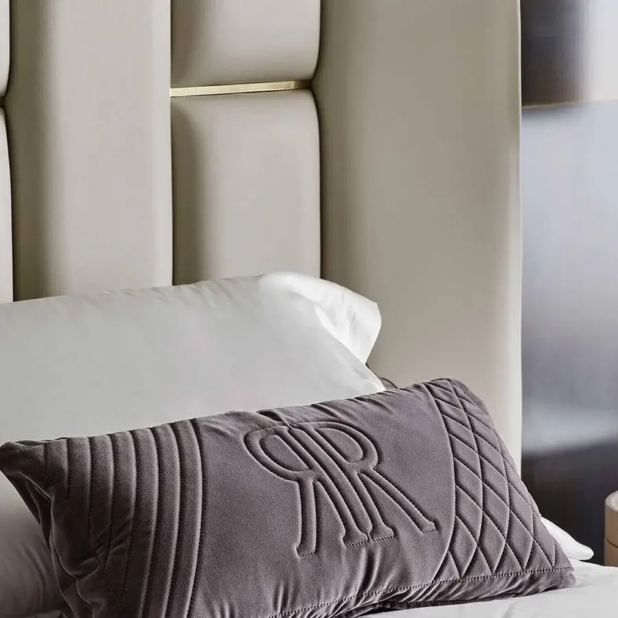 Lavish Rugiano Victoria bed with vertically segmented padding, light beige textile and stylish brass details