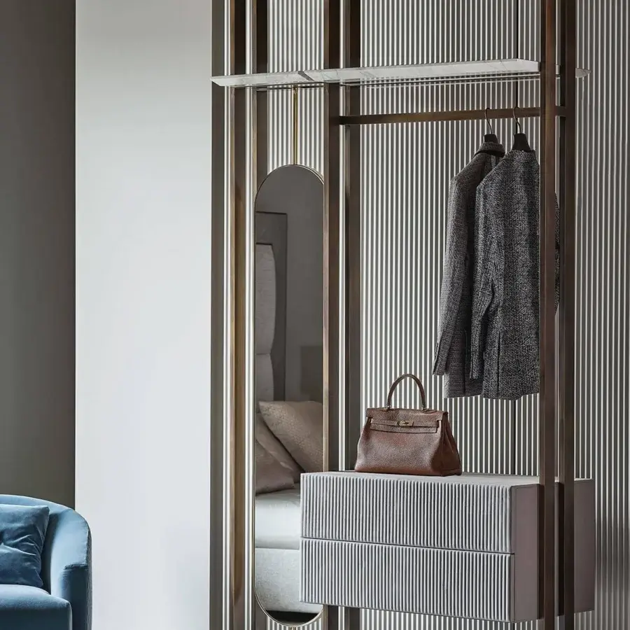 Distinguished Rugiano Matisse clothes rack with metal uprights, a white cabinet, rounded mirror and bronze finish