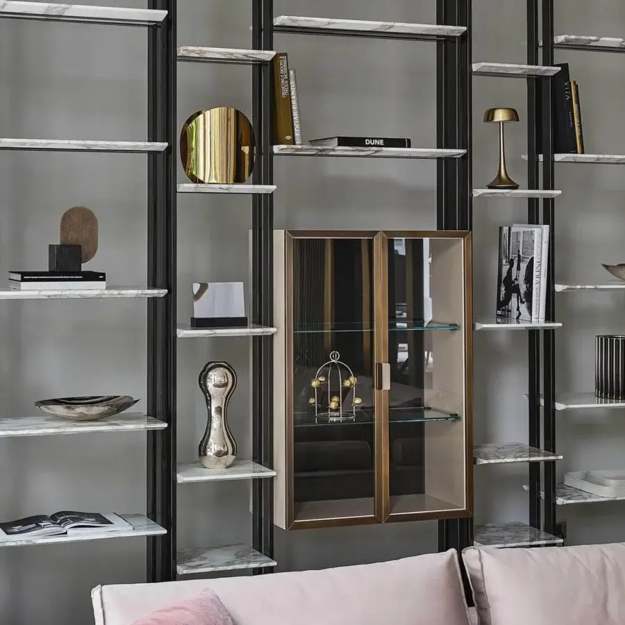 Elegant Rugiano Frame bookcase with cool white and gray marble shelves, a bronze metallic structure, plus light beige leather accents