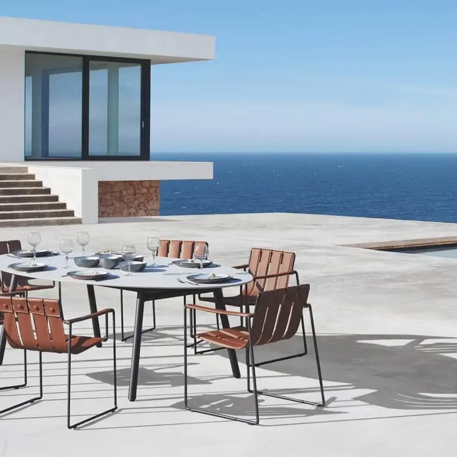Distinguished Royal Botania Styletto table with a round teak wood top and tapered coated aluminum legs