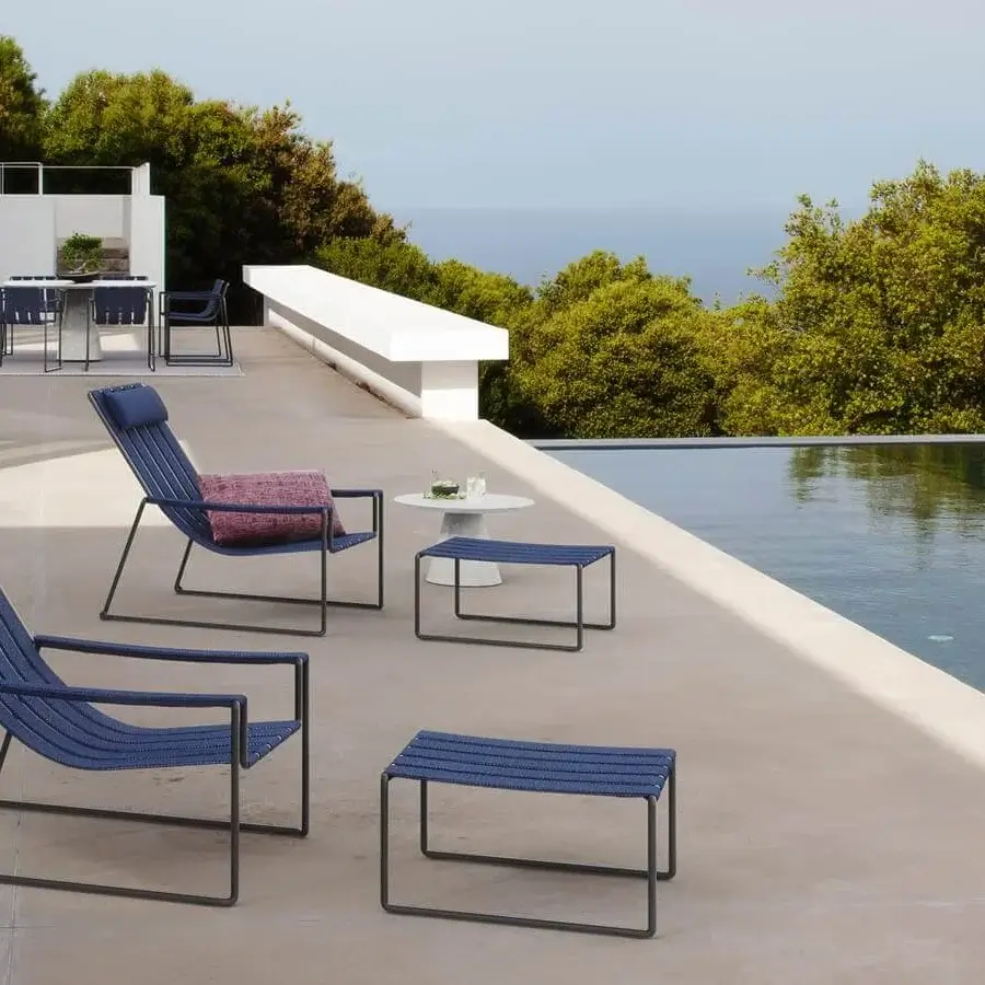 Distinguished Royal Botania Strappy lounger with a coated stainless steel structure and dark blue woven padded seat straps