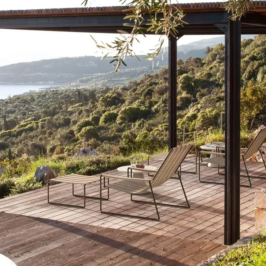 Elegant Royal Botania Strappy lounger with a dark coated stainless steel frame and light brown padded seat straps including a headrest cushion