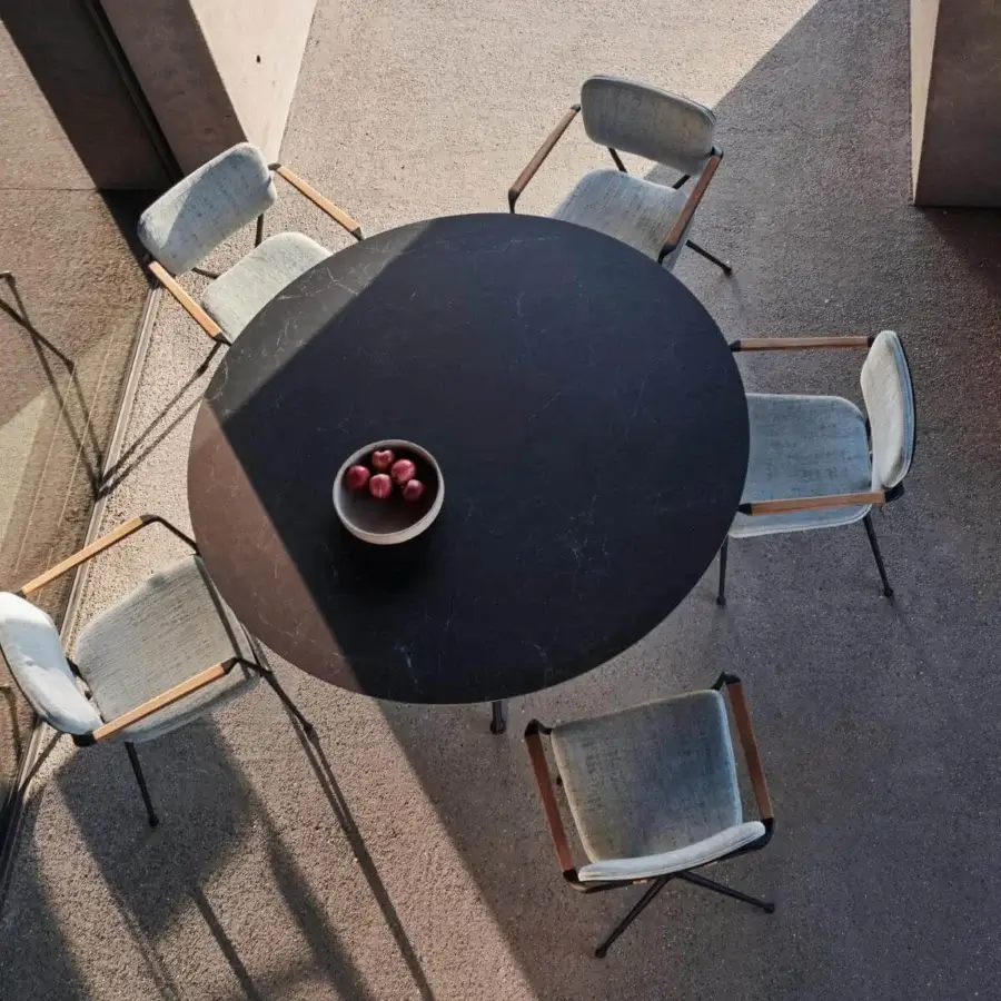 Distinguished Royal Botania Exes table with dark ceramic top revealing marbled patterns and intersecting coated aluminum legs