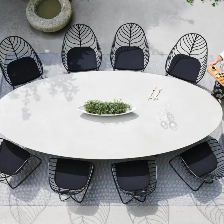 Elegant Royal Botania Exes table with light gray ceramic top and intersecting coated aluminum base offering understated design