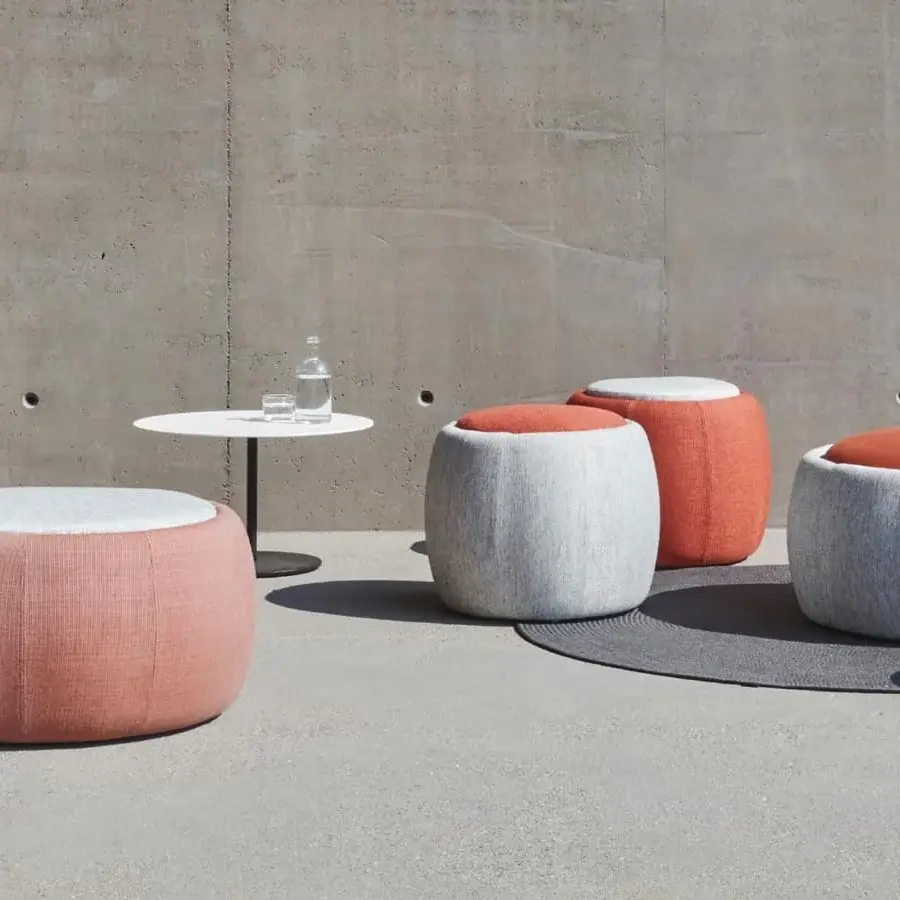 Distinguished Royal Botania Tono ottoman with woven textile cover in orange, pink and gray, revealing a hollow moulded plastic core