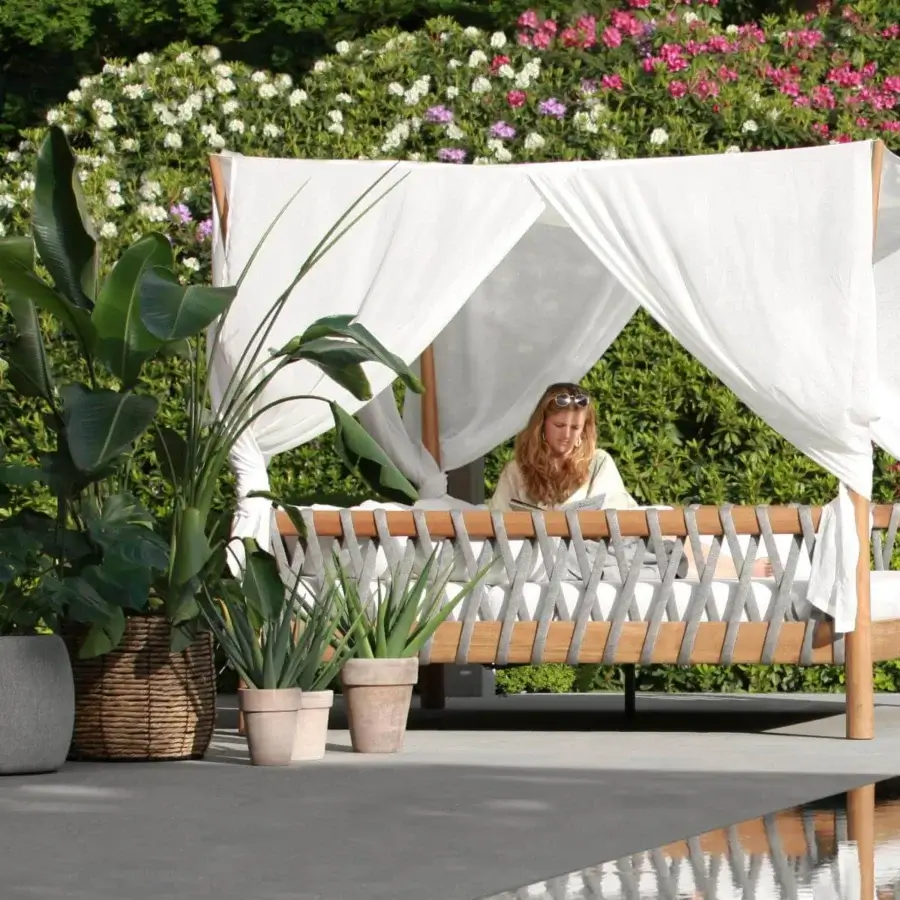 Distinguished Royal Botania Tuskany lounger with teak wood frame and woven olefin fiber sides in gray, topped with a plush light cushion