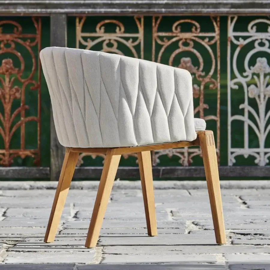 Exceptional Royal Botania Calypso armchair with light gray textured textile and smooth light-toned teak base, built with a geometrically patterned stainless steel backrest