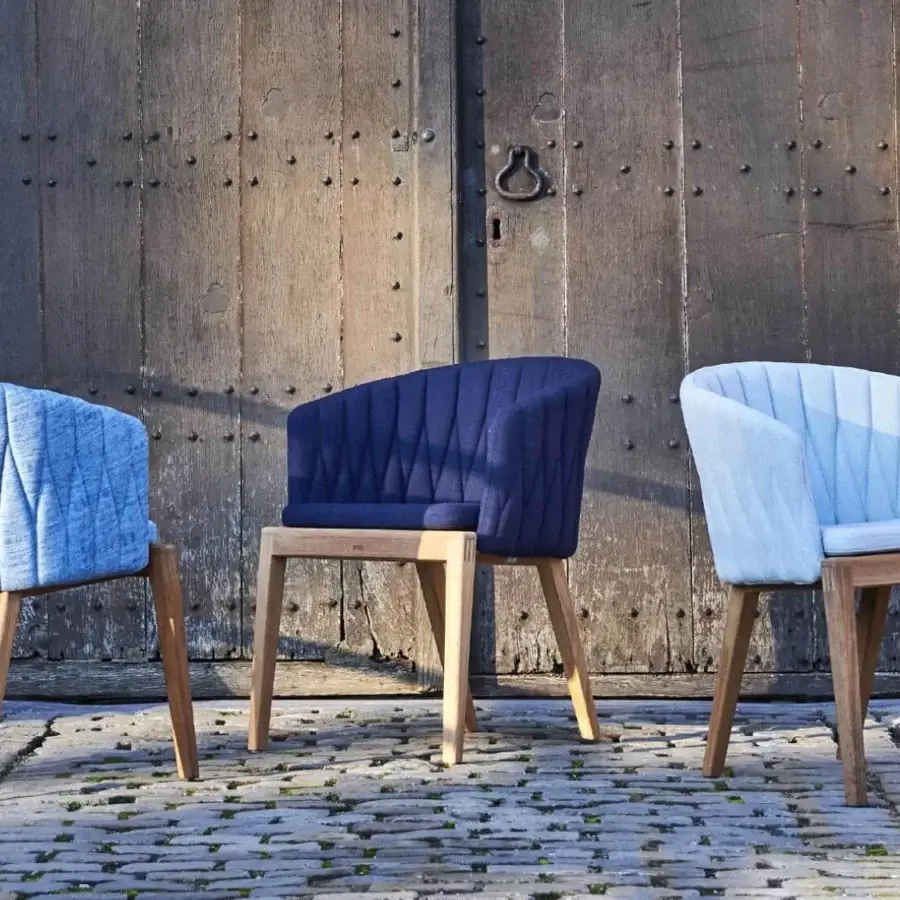 Exceptional Royal Botania Calypso armchair with light blue quilted textile upholstery and smooth teak with stainless steel base
