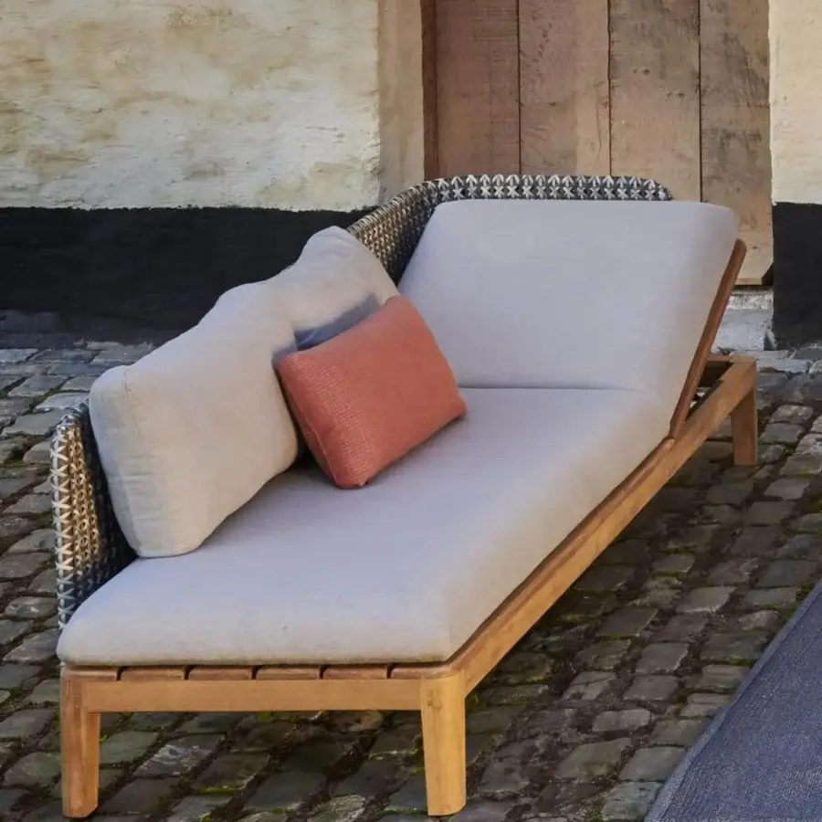 Elegant Royal Botania Calypso lounge lounger with a reclining teak base and stainless steel backrest upholstered in light gray textile