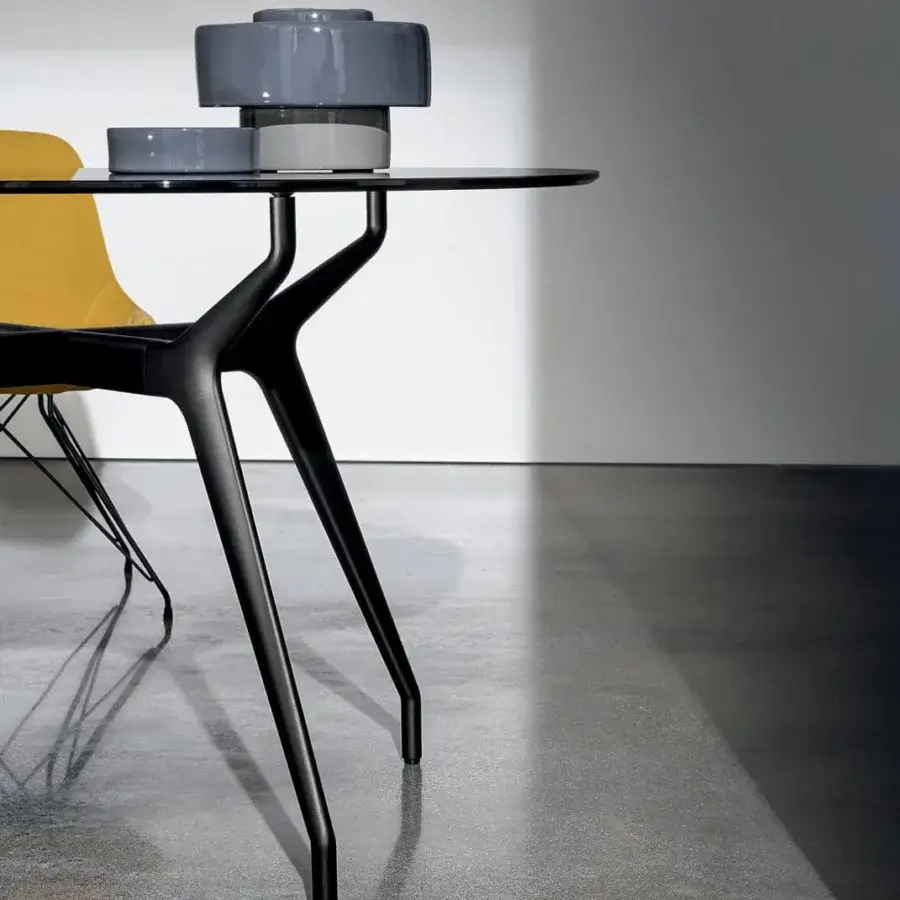Refined Sovet Italia Arkos table with rounded glass top and black matte aluminum X-shaped base crafted for contemporary interiors