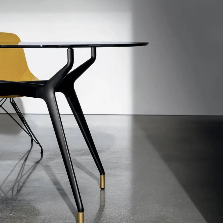 Superior Sovet Italia Arkos table with rounded glass top and matte black aluminum base crafted with golden accents