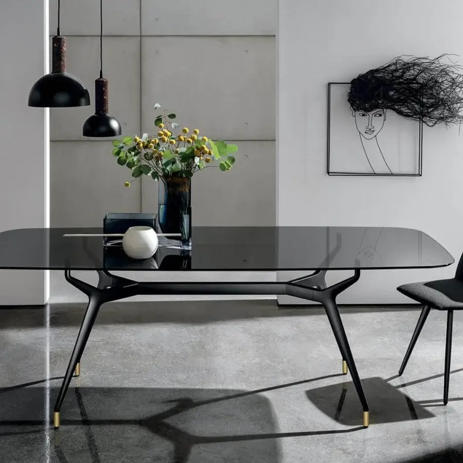 Elegant Sovet Italia Arkos table with a rectangular glass top and dark matte aluminum X legs with gold feet
