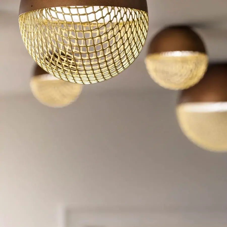 Sophisticated Masiero Iglù ceiling lamp with a bronze metal structure and matt gold metal mesh diffuser casts patterned light