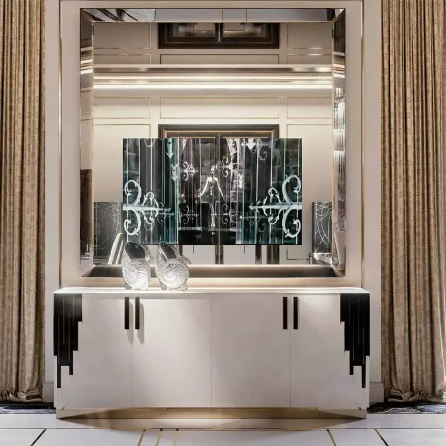 Horizontal cabinet with three doors sits beneath a framed mirror displaying a dark geometric pattern flanked by dark paneled walls