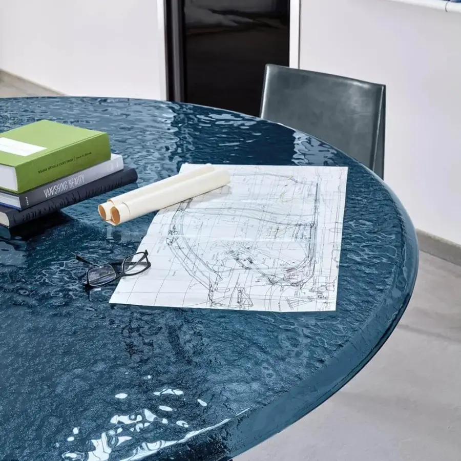 Exclusive Arketipo Avalon table presenting a contemporary silhouette with dark blue annealed glass and sculpted metal base crafted in Italy