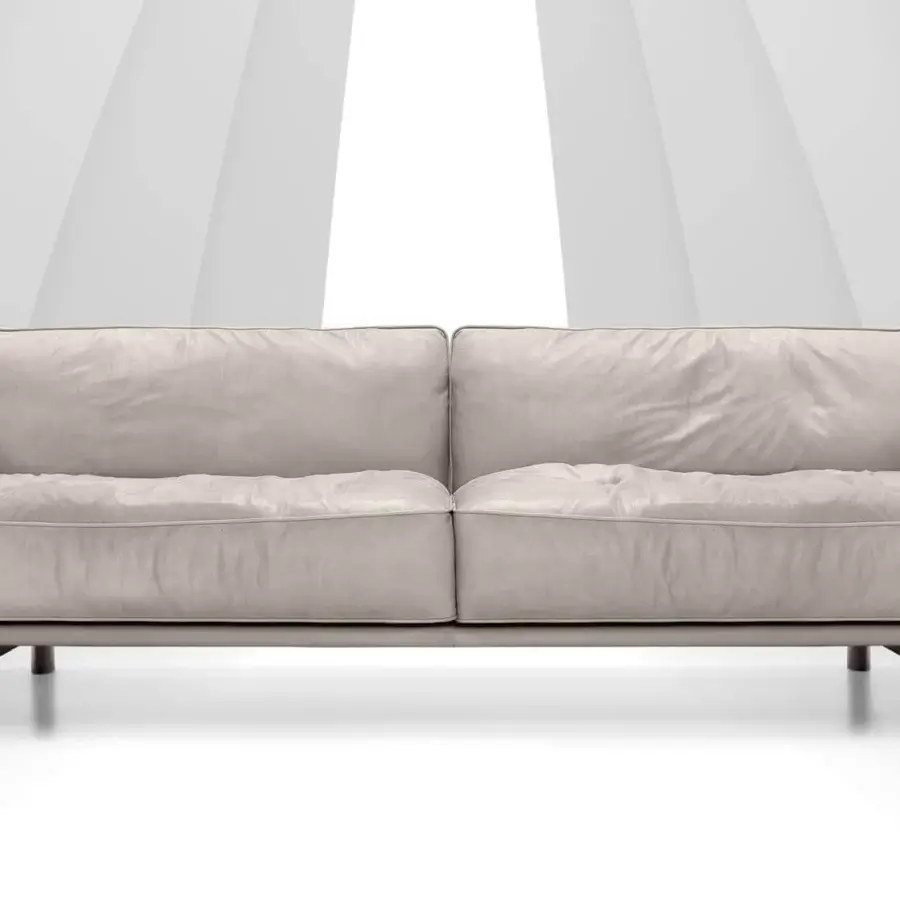 Superior Arketipo Close to Me sofa with billowy light beige cushions and uniquely expressive elliptical feet crafted in Italian leather