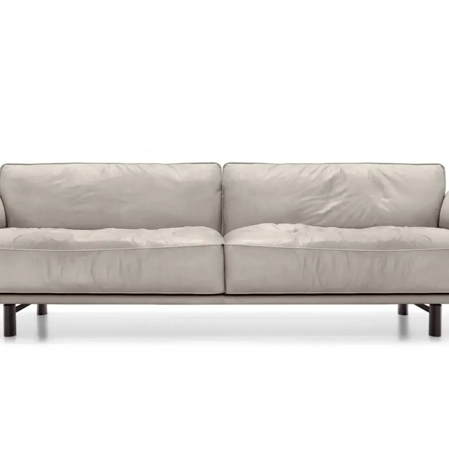 Elegant Arketipo Close to Me sofa with billowy light textile cushions and a crafted leather belt with sculptural feet
